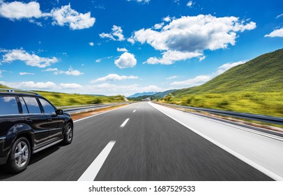 Tmavé auto na diaľnici v krásnej oblasti.