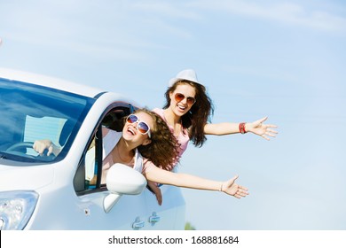 Young pretty women leaning out of car window