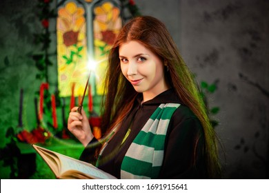 Seorang wanita muda bermantel hitam dengan syal bergaris di lehernya mengucapkan mantra dari sebuah buku dan menyulap dengan tongkat sihir.
