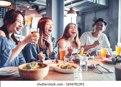 feliz grupo de jóvenes cenando y bebiendo cerveza en el restaurante