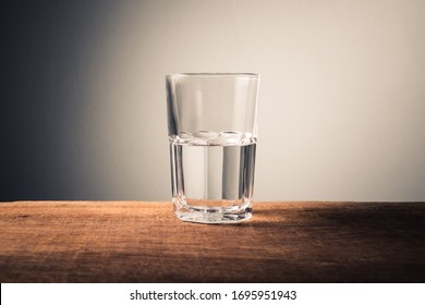Glas water met halfvol water op tafel, concept van positief en negatief denken