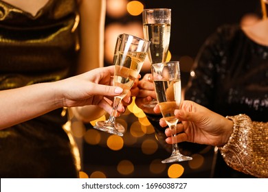 Wanita mendentingkan gelas sampanye lezat di pesta