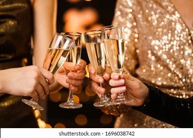 Wanita mendentingkan gelas sampanye lezat di pesta