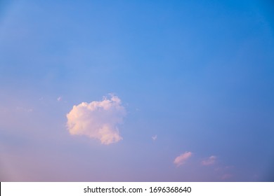 lonely soft clouds floating on blue sky,One white fluffy cloud floating in sky of blue in spring,Anime cloud image,A single puff of a cumulus cloud floats in the air,Cloud images of pink-blue tones.