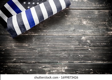 木製のヴィンテージの素朴な背景にアメリカの警察旗の細い青い線。