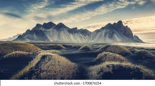 Слънчев пейзаж на Исландия. Прекрасна гледка към нос Stokksnes и планината Vestrahorn с черен пясък и трева на преден план през лятото. Емблематично място за пейзажни фотографи. Прекрасна природа.