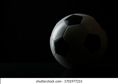 pelota de fútbol con sombra sobre fondo negro con espacio de copia