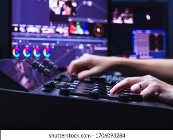 ビデオの色調を編集するためのカラー グレーディング ルーム スタジオ ラボでカラー グレーディング コントローラー マシンを操作している人の手