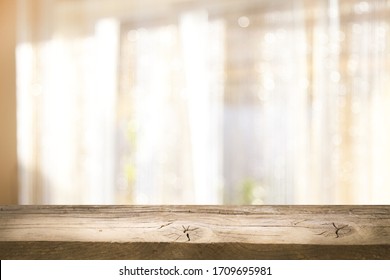 Top of wooden table on window glass blur. Of green from the garden of the vegetable garden on a morning background. To display product montage.