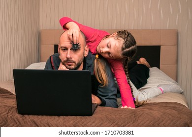 Un niño pone una araña de juguete sobre la cabeza de un hombre. Hija evita que papá trabaje en una computadora. La niña asusta al padre con un insecto. Concepto de familia cómica
