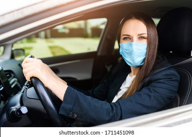 Young woman in smart casual in protective medical mask driving a car. Safety during coronavirus pandemic, epidemic covid-19