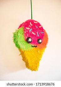 Handmade paper pinata, in the shape of ice cream, with a beautiful cheerful face