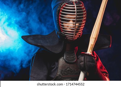 confiado luchador de kendo en armadura practicando con espada de bambú, preparándose para competiciones. samurái, concepto de kendo. espacio ahumado aislado