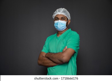 Porträt einer männlichen Krankenschwester, die mit den gefalteten Armen lokalisiert auf einem schwarzen Hintergrund steht. Asiatische Krankenschwester, die Kamera betrachtet. Männliche Krankenschwester mit schützender Gesichtsmaske gegen die Koronavirus-Epidemie COVID-19