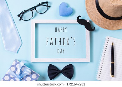 幸せな父の日のコンセプトです。ネクタイ、美しいギフト ボックス、帽子、明るい青のパステル調の背景に幸せな父の日のテキストと白い額縁の平面図です。フラットレイ。