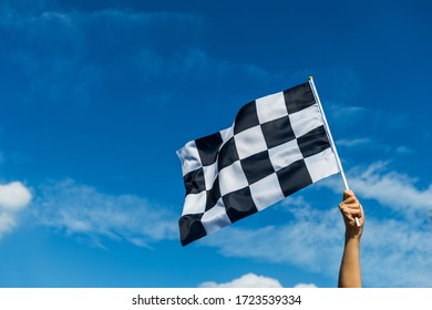 空気中の市松模様のレース旗を持っている手