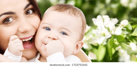 khái niệm gia đình và tình mẫu tử - người mẹ trẻ mỉm cười hạnh phúc với đứa con nhỏ trên nền hoa anh đào mùa xuân tự nhiên