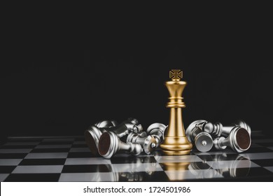 Gewinner. Goldkönig umgeben von silbernen Schachfiguren auf Schachbrettspielwettbewerb mit Kopierraum auf dunklem Hintergrund, Schachkampf, Erfolg, Teamleiter, Teamarbeit und Geschäftsstrategiekonzept