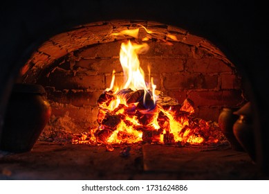 Village stove firewood and fire. Burning wood inside traditional oven