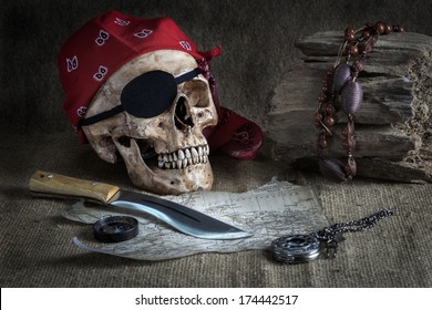 Still life, pirate skull with knife, compass and pocket watch on floor