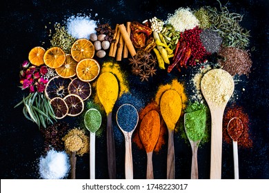Banyak rempah-rempah multi-warna dan buah-buahan kering di atas meja. Konsep latar belakang dengan rempah-rempah.