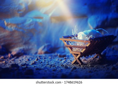 Conceito cristão de Natal. Nascimento de Jesus Cristo. Presépio de madeira em uma gruta ao fundo. Bandeira. Símbolo da Natividade. Jesus é o motivo da celebração. Salvação, Messias, Emanuel, Deus conosco, esperança.