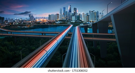 Đường cao tốc với những vệt sáng xe cộ dẫn đến cảnh quan thành phố hiện đại được chiếu sáng ban đêm. Hướng tới khái niệm thành phố thông minh. phương tiện truyền thông hỗn hợp.