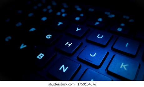 computer keyboard closeup in blue backlight