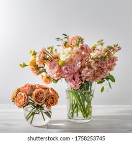 ピンクとオレンジのトルコギキョウ、キンギョソウ、さまざまな種類のユーカリのウェディング ブーケが、キッチン テーブルのガラスの花瓶に置かれています。テキスト用のスペース