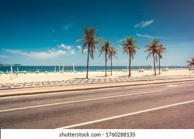Palmen auf Ipanema Beach mit blauem Himmel, Rio de Janeiro, Brasilien. Berühmtes Bürgersteigmosaik vor dem Strand