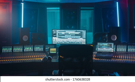 Shot van een Modern Music Record Studio Control Desk met computerscherm toont de gebruikersinterface van DAW-software met het afspelen van nummers. Equalizer, mixer en andere professionele apparatuur.