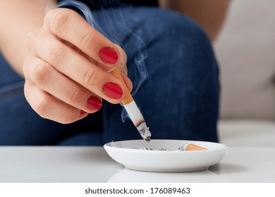 Mujer fumando cigarrillo y usando un cenicero