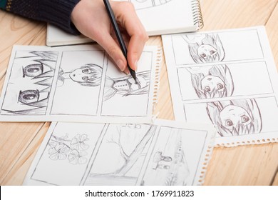 Artista dibujando un cómic de anime en un estudio. Escritorio de madera, luz natural. Concepto de creatividad e inspiración.
