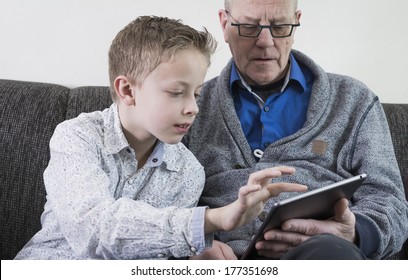 Đứa trẻ giải thích cho người đàn ông lớn tuổi cách sử dụng máy tính bảng máy tính bảng