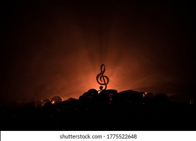 Muziekconcept. Muzikale symbool solsleutel roestvrijstalen miniatuur met kleurrijk getinte licht op mistige achtergrond. Selectieve focus