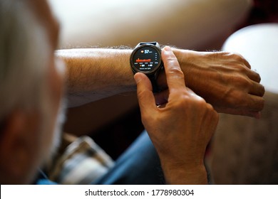 彼の心電図心電図をチェックするスマートな時計を使用して古い白髪の男