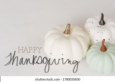 Witte minimalisme-pompoenen met happy thanksgiving-boodschap voor vakantie.