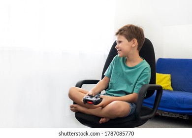 少年は、ヘッドフォンとジョイスティック、ゲーム機を使ってコンピューターゲームをします。