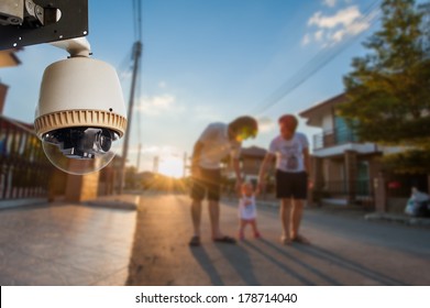 CCTV-camera die werkt met familie op de achtergrond van het dorp
