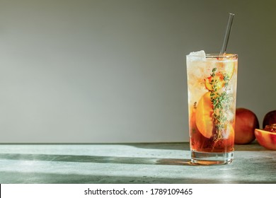 Thé glacé à la pêche rafraîchissant, Cuba Libre ou Long Island Iced Tea, servi dans un verre avec une paille. Boisson fruitée estivale rafraîchissante. Mise au point sélective