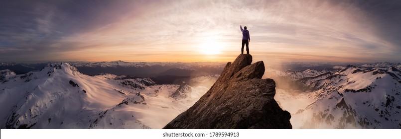 Composición de aventuras de fantasía mágica de un hombre caminando por la cima de una montaña rocosa. Paisaje de fondo de Columbia Británica, Canadá. Cielo colorido al amanecer o al atardecer