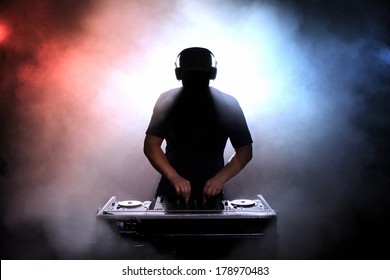 Schijf jokey, DJ, silhouet over mistige verlichte achtergrond