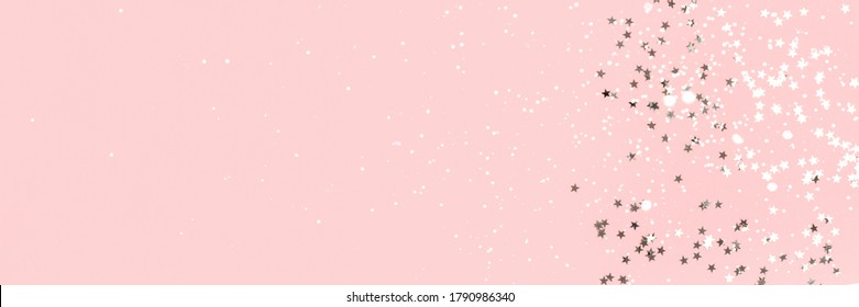 Silver stars confetti on a pink pastel background. Holidays banner with place for text.