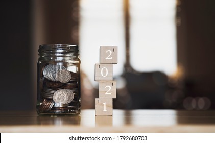 Đồng xu chuỗi bảng Anh và đồng xu trong lọ với năm 2021 trên chồng gỗ có nền mờ, Kế hoạch tài chính cho năm mới 2021 Nghị quyết để tiết kiệm tiền cho tương lai trong kinh doanh hoặc cuộc sống