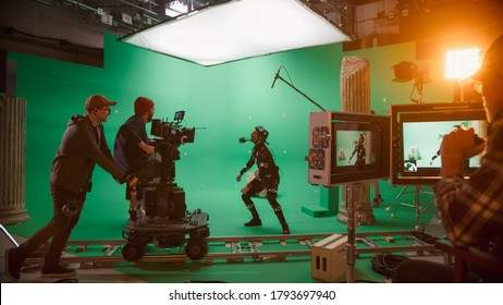 In the Big Film Studio Professional Crew Shooting Blockbuster Movie. Director Commands Cameraman to Start shooting Green Screen CGI Scene with Actor Wearing Motion Tracking Suit and Head Rig