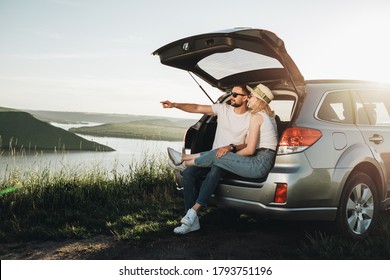 Hombre y mujer relajándose dentro del maletero del coche disfrutando del viaje de fin de semana, el concepto de viaje y aventura