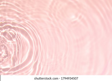 Primer plano de la textura de la superficie del agua tranquila transparente rosa con salpicaduras y burbujas. Fondo de naturaleza de verano abstracto de moda. Ondas de color coral a la luz del sol.