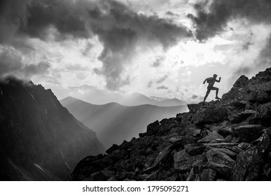Fotografía deportiva en blanco y negro en las montañas. Corredor de senderos en las montañas de verano por la noche. cielo del atardecer y espacio de edición en segundo plano