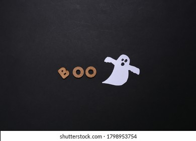 Paper ghost and the word BOO on a black background. Halloween theme