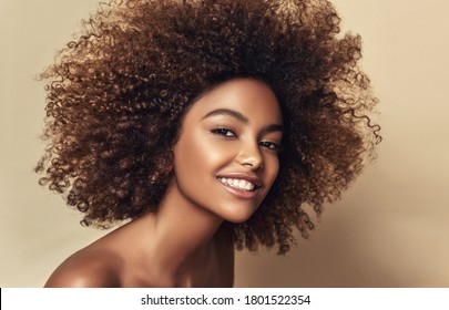 Schönheitsporträt der Afroamerikanerfrau mit sauberer gesunder Haut auf beigem Hintergrund. Lächelndes schönes Afro-Mädchen. Kurze schwarze Haare